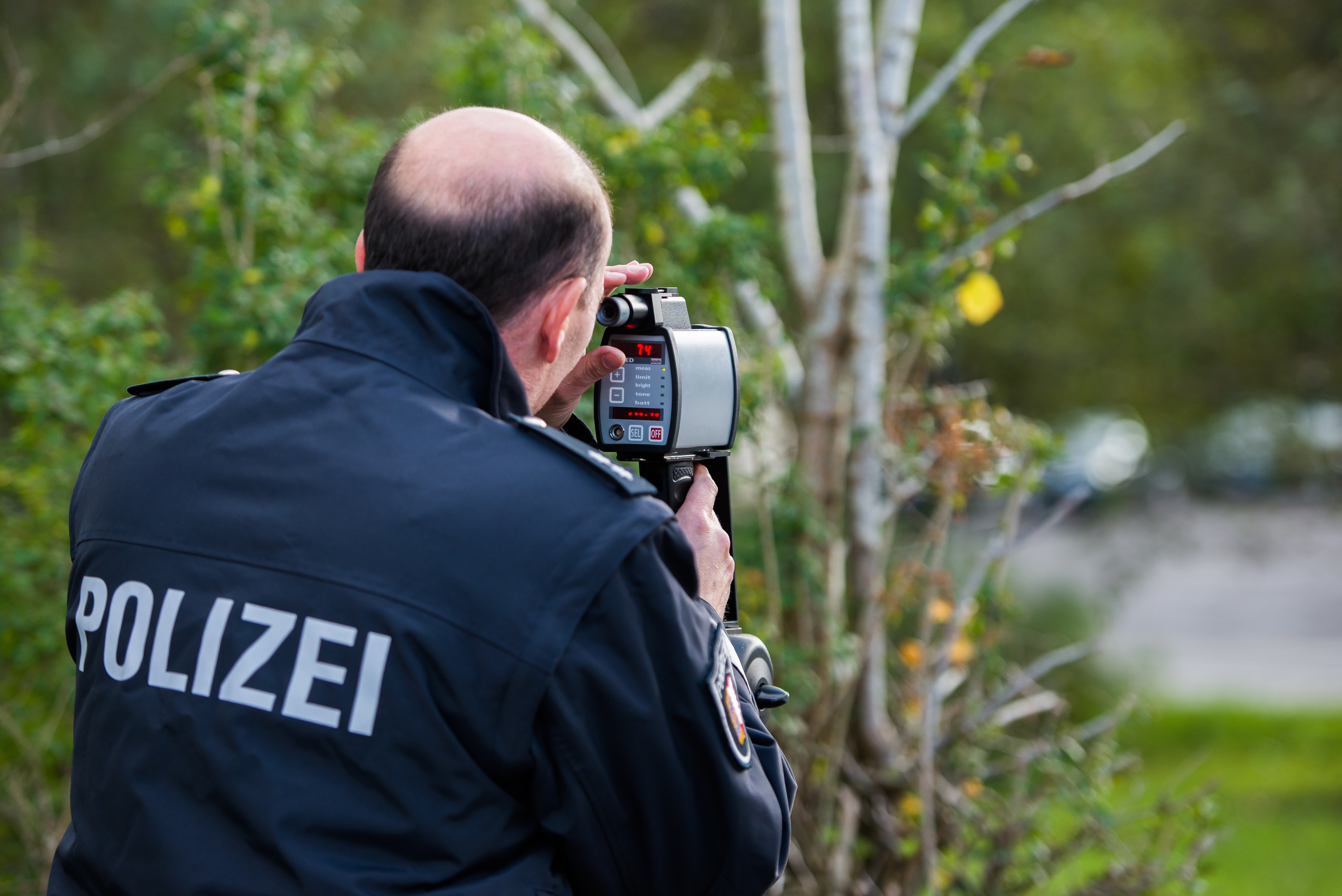 Polizist mit Laserpistole zur Geschwindigkeitsmessung