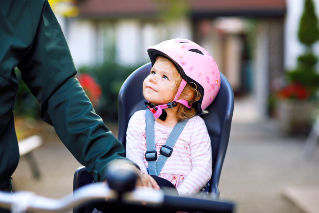 Kind mit Fahrradhelm im Kindersitz