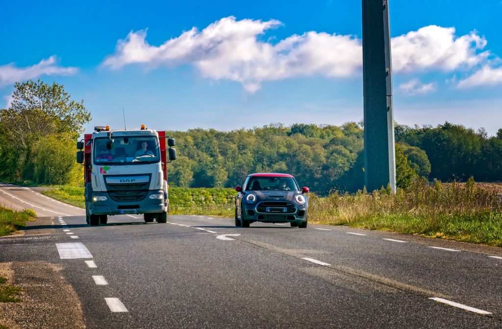 Auto überholt Lkw auf Landstraße 