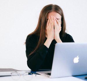 Auf dem Bild ist eine verzweifelte Arbeitnehmerin zu sehen, die ihre Abmahnung anfechten möchte.