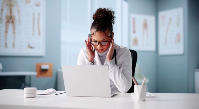 Das Foto zeigt eine verzweifelte Ärztin und spiegelt das Thema »Anwalt für Arztstrafrecht« wider.