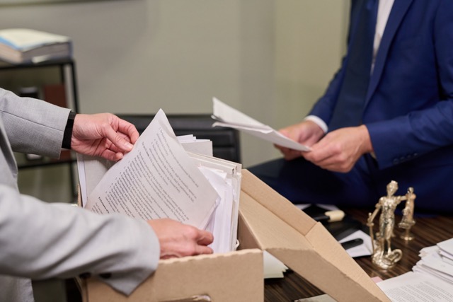 Das Bild zeigt die Durchsuchung eines Büros zur Sicherstellung von Beweismitteln.